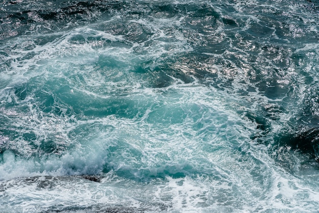 Foto bewegung der meerwasseroberfläche mit stein, spritzen des blauen wassers