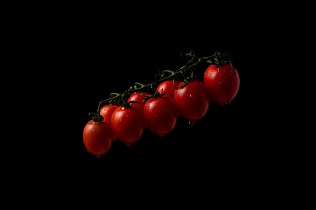 Bewegung einfrieren. Kirschtomaten auf schwarzem Hintergrund mit Spritzwasser