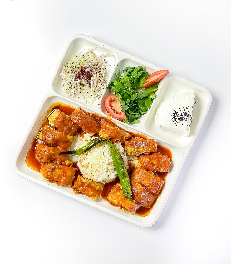 Beyti Kebab turco tradicional con yogur, tomates asados y verduras frescas.