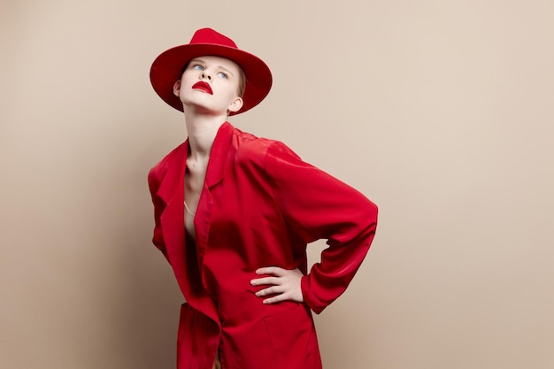 Bezaubernde Frau in einem roten Hut- und Jackenmake-up lokalisierte Hintergrund