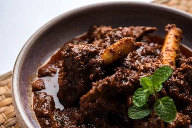 Bhuna Gosht Mutton Masala ODER indisches Lammcurry Serviert in einer Schüssel über stimmungsvollem Hintergrund. Selektiver Fokus