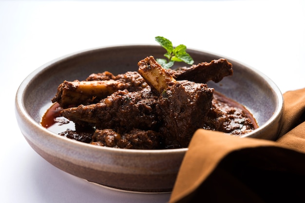 Bhuna Gosht Mutton Masala ODER indisches Lammcurry Serviert in einer Schüssel über stimmungsvollem Hintergrund. Selektiver Fokus