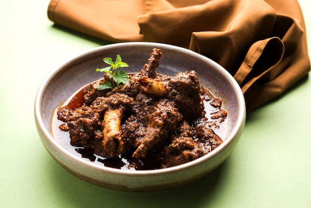 Bhuna Gosht Mutton Masala ODER indisches Lammcurry Serviert in einer Schüssel über stimmungsvollem Hintergrund. Selektiver Fokus