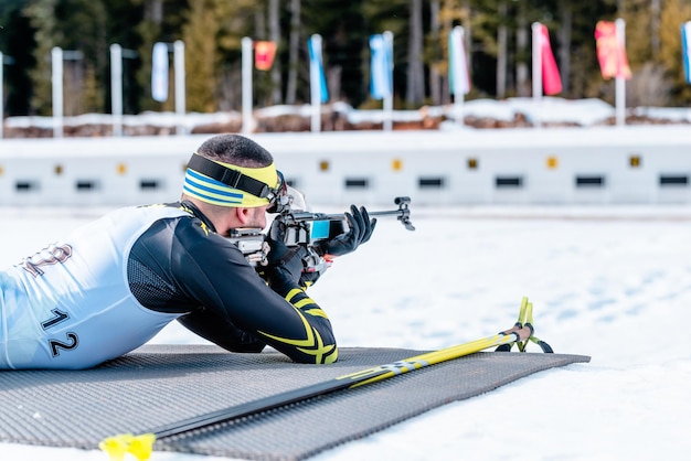 Biatleta disparando con un rifle en un campo de tiro en la carrera