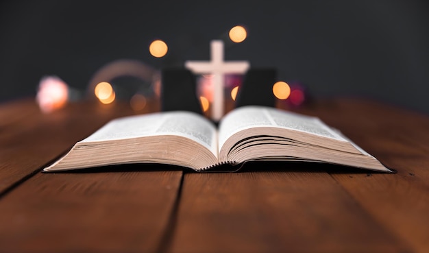 Bibel mit Kreuz auf Bokeh-Hintergrund