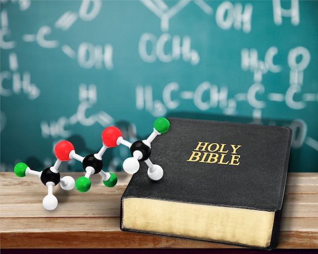 Bibel und Chemie bilden auf Holztisch