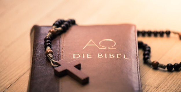 Bibel und Rosenkranz Christliche Bibel und Rosenkranz auf einem Holztisch