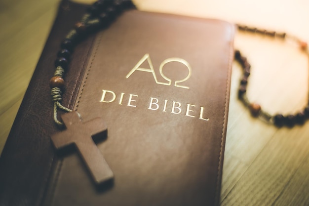 Bibel und Rosenkranz Christliche Bibel und Rosenkranz auf einem Holztisch