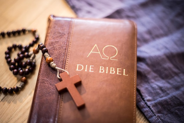 Bibel und Rosenkranz Christliche Bibel und Rosenkranz auf einem Holztisch