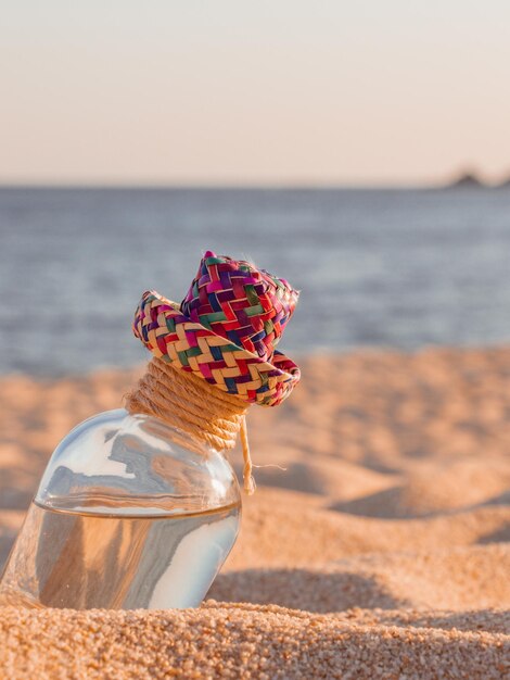 Biberón de mezcal oaxaqueño en la arena de la playa