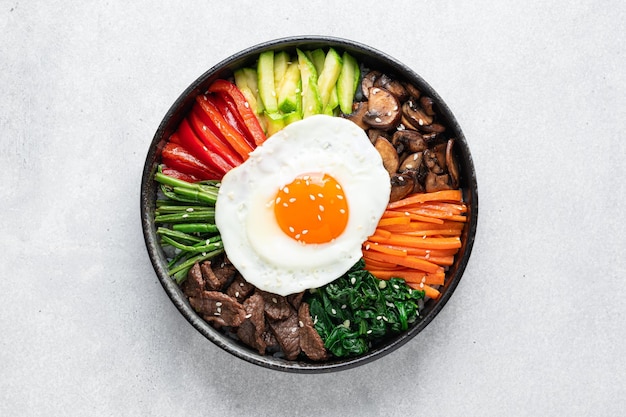 Bibimbap auf einem konkreten Hintergrund traditionelles koreanisches Gericht Draufsicht