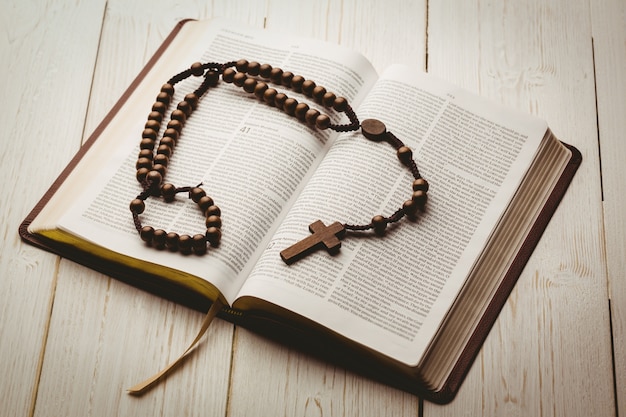 Biblia abierta y rosarios de madera