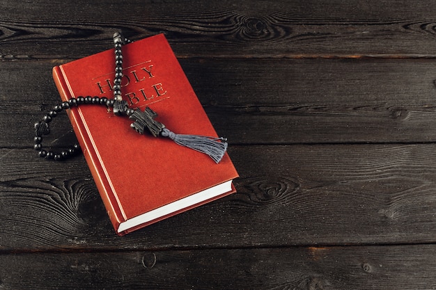 Biblia y un crucifijo en una vieja mesa de madera. Concepto de religión