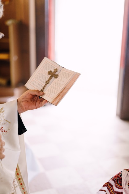 Bíblia e a cruz na mão do padre closeup
