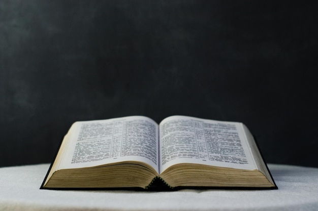 Foto bíblia em uma mesa branca redonda com contas fundo escuro bonito conceito religioso