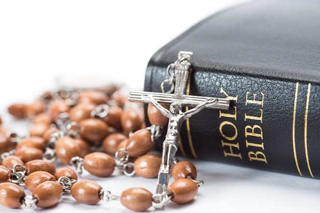 Biblia encuadernada en cuero negro con cuentas de rosario