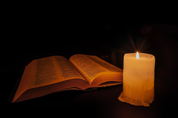 Bíblia na mesa à luz de uma vela