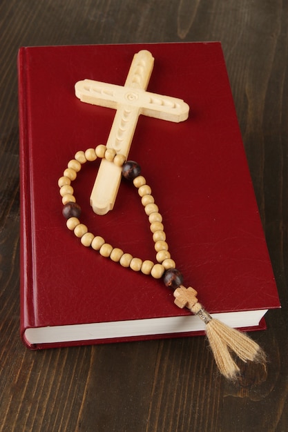 Biblia, rosario y cruz en primer plano de la mesa de madera