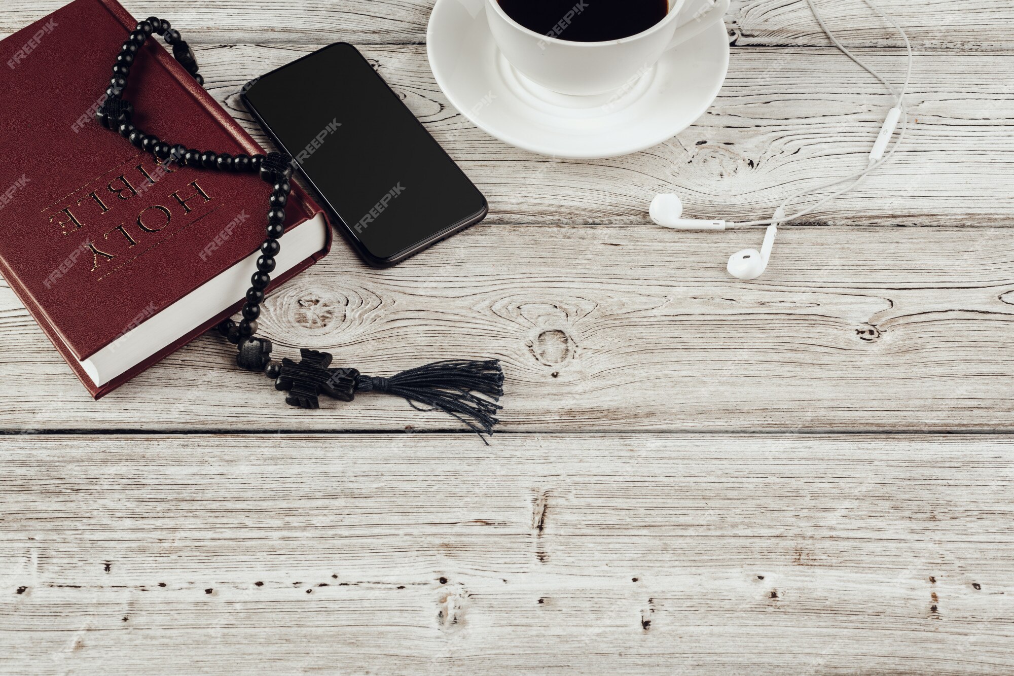 Foto Bíblia aberta ao lado de xícara de café e smartphone na mesa