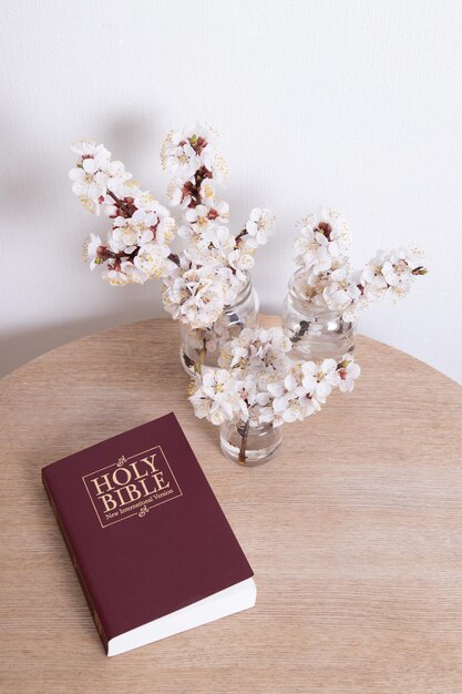 Bíblia Sagrada na mesa com galho de primavera florescendo