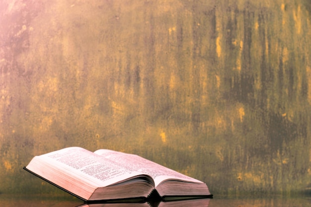 Biblia en una vieja mesa de madera hermoso fondo oscuro concepto religioso