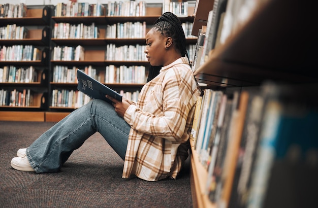 Bibliothek College-Student und schwarze Frau lesen Bücher im Erdgeschoss für Bildung und Campus-Lernen Studentin und Bücherregal für Projektwissen und Akademieforschung