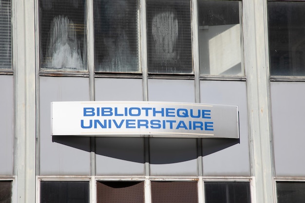 Bibliotheque universitaire-Schild mit französischem Text an der Fassade der Universitätsbibliotheksgebäude-Studentin im Stadtzentrum