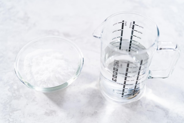 Bicarbonato de sódio e vinagre em recipientes de vidro para limpar braseiro esmaltado de ferro fundido