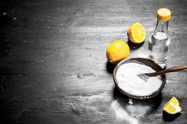 Bicarbonato de sodio en un bol con vinagre y rodajas de limón.