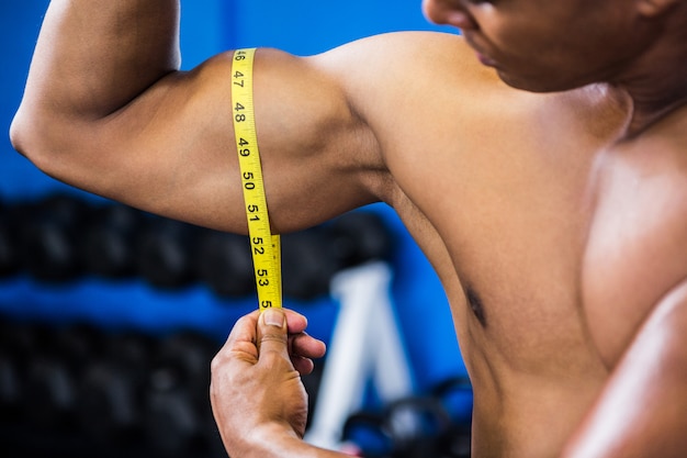Bíceps de medição homem musculoso