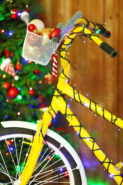 Bicicleta amarilla cerca del árbol de Navidad