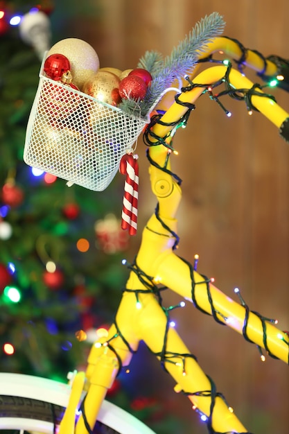 Bicicleta amarilla cerca del árbol de Navidad