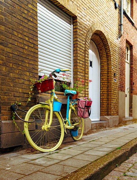 Foto bicicleta antigua en una calle belga con flores