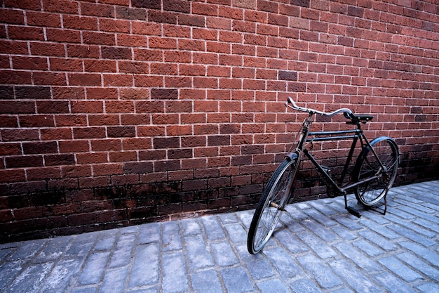 Bicicleta antigua con fondo de ladrillo rojo. Concepto vintage