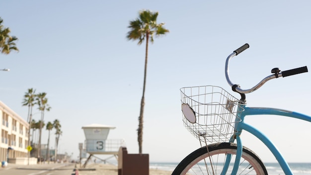 Bicicleta azul, bicicleta cruzador na praia do oceano do mar, costa da califórnia, eua. pedale perto da torre do salva-vidas.