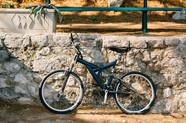 Bicicleta azul junto ao meio-fio de pedra na rua