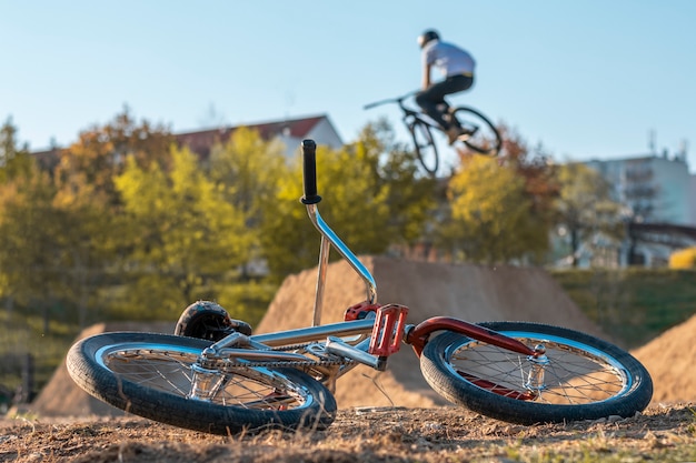 Bicicleta BMX en la pista con saltos en el fondo con casas