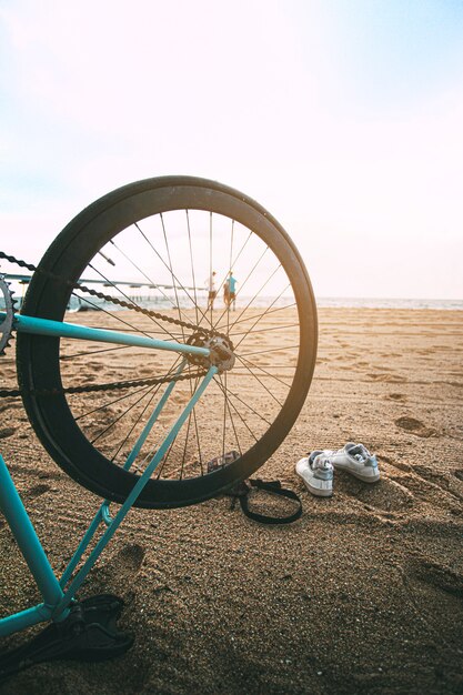 Bicicleta boca abajo en la playa Jóvenes mirando el amanecer Espacio de copia Deportes