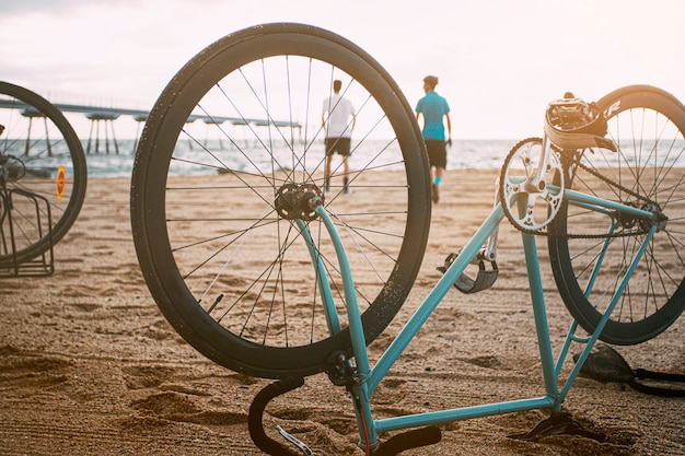 Bicicleta boca abajo sobre la arena Los jóvenes disfrutan de su tiempo libre en la playa Espacio de copia