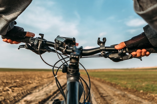 Bicicleta en el camino del campo. Vista desde los ojos de los ciclistas.