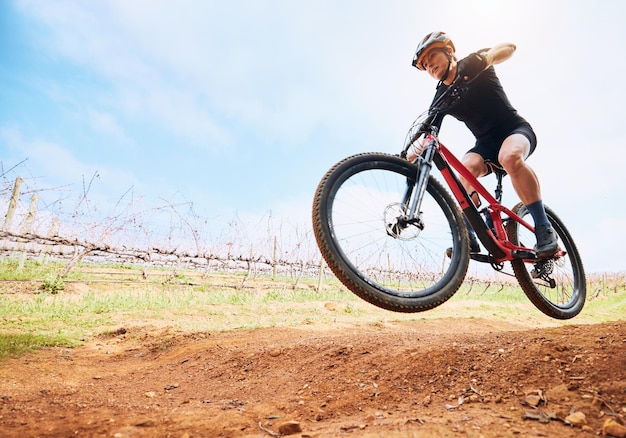 Bicicleta de campo y mujer en una bicicleta con velocidad para carreras deportivas en un camino de tierra Ejercicio físico y atleta haciendo entrenamiento deportivo en la naturaleza en un sendero del parque para maquetas de ejercicios cardiovasculares y ciclistas
