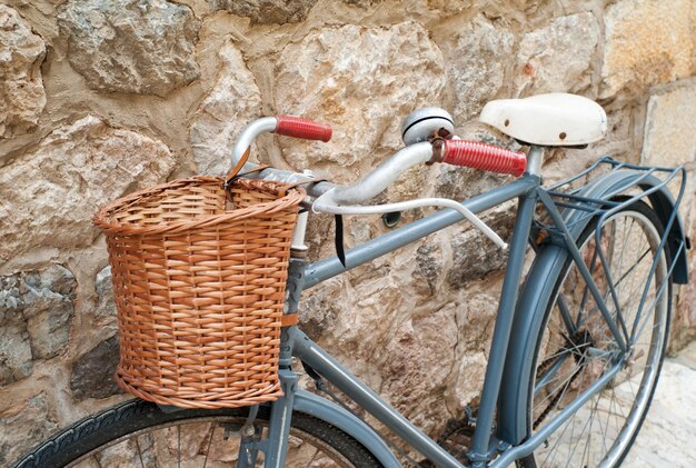 Foto bicicleta con canasta estacionada junto a la pared