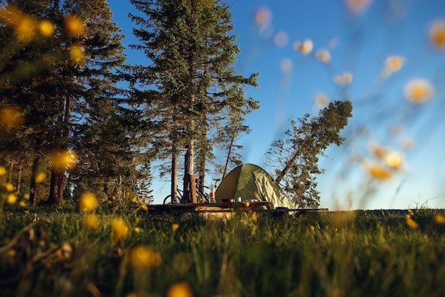 Foto bicicleta de carpa y hermoso lugar para acampar con río en el concepto de ciclismo de turismo al amanecer