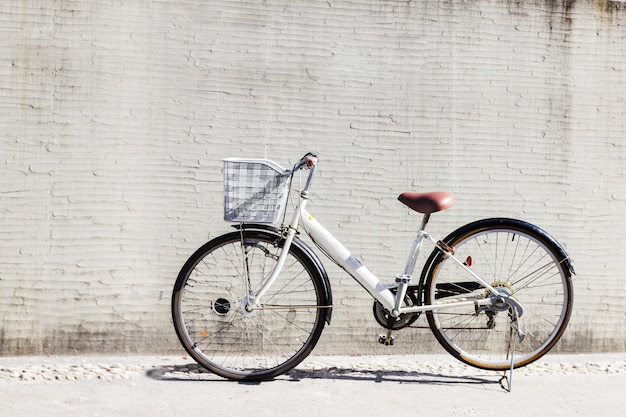 Foto bicicleta com cesta na frente da parede branca