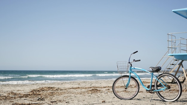 Bicicleta cruiser bike pela praia do oceano costa da califórnia eua verão mar costa ciclo pela torre salva-vidas