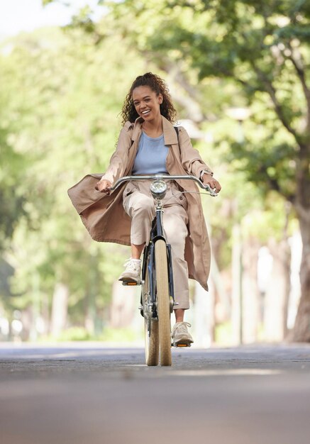 Foto bicicleta de viagem e mulher negra com transporte de sorriso e fitness com deslocamento de bicicleta e natureza bicicleta feminina afro-americana e feliz senhora aventura ao ar livre e passeios no fim de semana e diversão