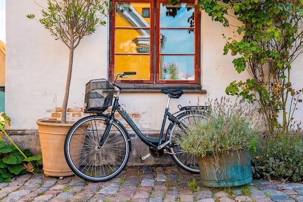 Bicicleta estacionada cerca de la pared amarilla de una casa antigua en un pueblo europeo tradicional clásico.