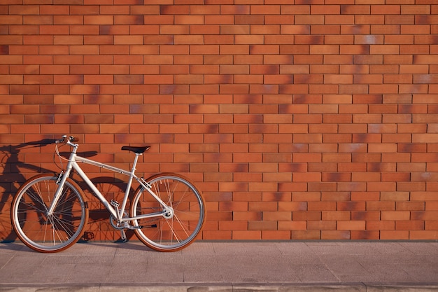 Bicicleta estacionada cerca de la pared de ladrillo