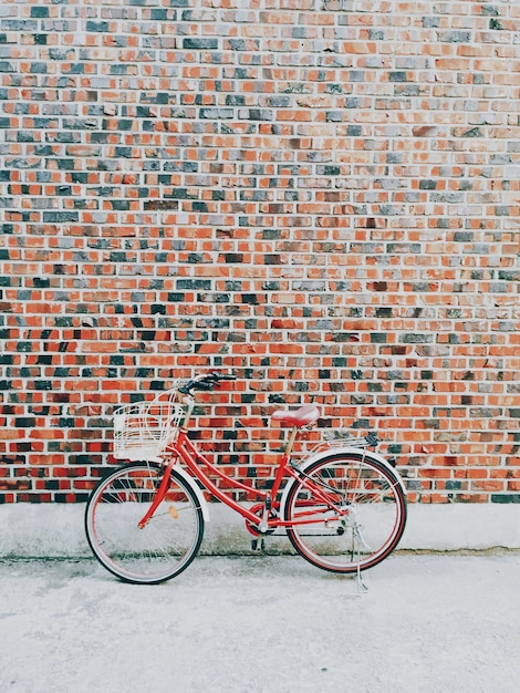 Bicicleta estacionada contra una pared de ladrillo
