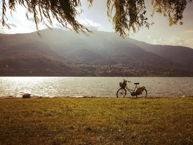 Foto bicicleta estacionada junto al lago contra la montaña